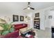 Inviting living room with a red sofa, stylish decor, and modern ceiling fan at 10297 Sierra Skye Ave, Las Vegas, NV 89166