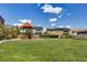 A spacious neighborhood park with a modern playground surrounded by green grass and mature trees at 10297 Sierra Skye Ave, Las Vegas, NV 89166