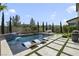 A modern backyard features a sparkling pool with lounge chairs and a waterfall, and lush landscaping for a tranquil retreat at 10297 Sierra Skye Ave, Las Vegas, NV 89166