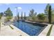 Backyard pool featuring a waterfall, lounge chairs, and mature landscaping at 10297 Sierra Skye Ave, Las Vegas, NV 89166