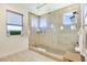 Modern walk-in shower with neutral stone-look tile, glass enclosure, and multiple shower heads at 10297 Sierra Skye Ave, Las Vegas, NV 89166