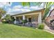Lush backyard view featuring a covered patio, vibrant green lawn, mature trees, and well-maintained grounds at 10404 Stanberry Ave, Las Vegas, NV 89135