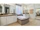 Bathroom with a sunken tub, double sinks, and neutral tile flooring at 10404 Stanberry Ave, Las Vegas, NV 89135