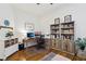 Bright home office featuring hardwood floors, dual monitors, and a built-in bookshelf for added storage and display at 10404 Stanberry Ave, Las Vegas, NV 89135