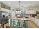 Bright kitchen featuring stainless appliances, island with bar seating, granite countertops, and a tile backsplash at 10404 Stanberry Ave, Las Vegas, NV 89135