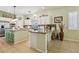 Bright kitchen featuring stainless appliances, an island with bar seating, granite countertops, and tile flooring at 10404 Stanberry Ave, Las Vegas, NV 89135