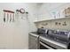 Laundry room with stainless steel washer and dryer, shelving, and hanging rack at 10404 Stanberry Ave, Las Vegas, NV 89135