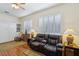 Bright living room featuring hardwood floors, plantation shutters, a Murphy bed, and a comfortable recliner sofa at 10404 Stanberry Ave, Las Vegas, NV 89135