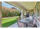 Inviting covered patio featuring a glass table with chairs and a lush backyard view with mature landscaping at 10404 Stanberry Ave, Las Vegas, NV 89135