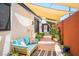 Back patio with blue outdoor couch, canvas shade sail, and lush potted plants at 108 Verdy Ln, Las Vegas, NV 89101