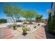 Private backyard with a small seating area, decorative trees, and brick-lined pathways at 108 Verdy Ln, Las Vegas, NV 89101