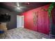 Bedroom featuring a red accent wall with vines, black brick wall, ceiling fan, and stylish laminate floors at 108 Verdy Ln, Las Vegas, NV 89101