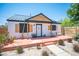 Single-story home with charming front porch with outdoor seating, drought-resistant landscaping, and modern fence at 108 Verdy Ln, Las Vegas, NV 89101