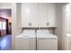 Functional laundry area with front-loading washer and dryer, and ample overhead cabinet storage at 108 Verdy Ln, Las Vegas, NV 89101