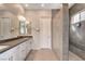 Large bathroom featuring tiled shower with bench, dual sinks and quartz countertops at 10985 Limeslice Ave # 2, Las Vegas, NV 89135