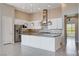 Gourmet kitchen features a large island, pendant lights, stainless steel appliances, and mosaic backsplash at 10985 Limeslice Ave # 2, Las Vegas, NV 89135