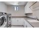 Convenient laundry room with washer, dryer, sink, and ample cabinet space at 10985 Limeslice Ave # 2, Las Vegas, NV 89135