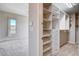 View of the walk-in closet with shelving, drawers, and hanging racks, located near bedroom with large window at 10985 Limeslice Ave # 2, Las Vegas, NV 89135