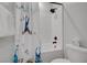 Bathroom shower with a fun ocean-themed curtain, black fixtures and a white tiled bathtub at 1321 Hudson Creek Pl, North Las Vegas, NV 89084