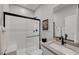 Modern bathroom featuring a walk-in shower with white subway tile, sleek black hardware, and a floating vanity at 1321 Hudson Creek Pl, North Las Vegas, NV 89084