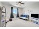 Neutral toned bedroom featuring a daybed with blue pillows, ceiling fan, and a TV at 1321 Hudson Creek Pl, North Las Vegas, NV 89084