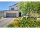 Charming two-story home with a brick driveway, two-car garage, and lush landscaping at 1321 Hudson Creek Pl, North Las Vegas, NV 89084