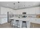 Modern kitchen boasts white cabinets, stainless appliances, and a large island with barstool seating at 1321 Hudson Creek Pl, North Las Vegas, NV 89084