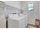 Bright laundry room features a washing machine, dryer, shelving and an ironing board at 1321 Hudson Creek Pl, North Las Vegas, NV 89084