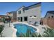 Inviting kidney-shaped pool with a lounging area, surrounded by a brick fence and lush tropical accents at 1321 Hudson Creek Pl, North Las Vegas, NV 89084