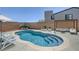 Inviting kidney-shaped pool with shallow steps, surrounded by a brick fence and comfortable lounging area at 1321 Hudson Creek Pl, North Las Vegas, NV 89084