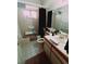 Bright bathroom with a shower-tub combo, toilet, and a vanity with a mirror, plus assistive chair at 1407 Santa Margarita St # A, Las Vegas, NV 89146