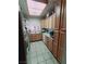 An efficient kitchen with light wood cabinets, tile floors, and basic appliances at 1407 Santa Margarita St # A, Las Vegas, NV 89146