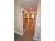 Hallway featuring a closet with mirrored doors and a view into a bathroom with dual vanities and a toilet at 220 E Flamingo Rd # 116, Las Vegas, NV 89169