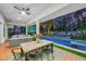 Stylish covered patio featuring an outdoor dining set and a cozy lounge area overlooking the pool and lush backyard at 2231 S Tioga Way, Las Vegas, NV 89117