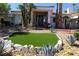 Charming home with desert landscaping, mature palms, and an artificial grass detail at 2231 S Tioga Way, Las Vegas, NV 89117