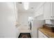 Well-lit laundry room with front-loading washer and dryer, ample cabinetry, and a neutral color palette at 2231 S Tioga Way, Las Vegas, NV 89117