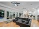 A bright living room featuring a comfortable gray sectional sofa, wood floors, and access to an outdoor pool area at 2231 S Tioga Way, Las Vegas, NV 89117