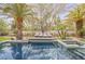 Gorgeous pool area with lounge chairs on a tanning deck surrounded by lush landscaping and mature palm trees at 2231 S Tioga Way, Las Vegas, NV 89117