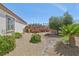 Landscaped backyard featuring desert plants, bushes, and a charming rock stream at 2284 Carambala Ln, Henderson, NV 89044