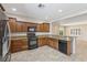 Well-lit kitchen featuring granite countertops, stainless steel refrigerator, and wooden cabinets at 2284 Carambala Ln, Henderson, NV 89044