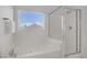 Bathroom showing a soaking tub and shower with a window view at 236 Dog Leg Dr, Las Vegas, NV 89148