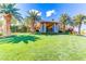 A clubhouse with stone pillars and manicured landscaping, surrounded by palm trees at 236 Dog Leg Dr, Las Vegas, NV 89148