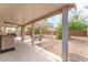 Inviting covered patio with fan, plus a seating area and desert landscaping perfect for outdoor living at 2413 Mourning Warbler Ave, North Las Vegas, NV 89084