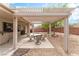 Relaxing backyard oasis with covered patio, desert landscaping, and outdoor dining area at 2413 Mourning Warbler Ave, North Las Vegas, NV 89084