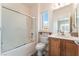 Well-lit bathroom with a combined shower and tub and vanity with a sink and storage at 2413 Mourning Warbler Ave, North Las Vegas, NV 89084
