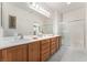 Bathroom featuring a dual-sink vanity, and a tiled shower at 2413 Mourning Warbler Ave, North Las Vegas, NV 89084