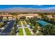 Aerial view of the community with bocce ball and tennis courts surrounded by trees and mountains at 2413 Mourning Warbler Ave, North Las Vegas, NV 89084