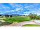Scenic view of the golf course and the mountains. A lush, green landscape stretches out under a vibrant blue sky at 2413 Mourning Warbler Ave, North Las Vegas, NV 89084
