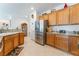 Kitchen with granite countertops, stainless steel refrigerator, and wood cabinets at 2413 Mourning Warbler Ave, North Las Vegas, NV 89084