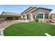 Landscaped backyard with artificial grass, brick patio, and inviting seating areas for outdoor entertaining at 2425 Sturrock Dr, Henderson, NV 89044